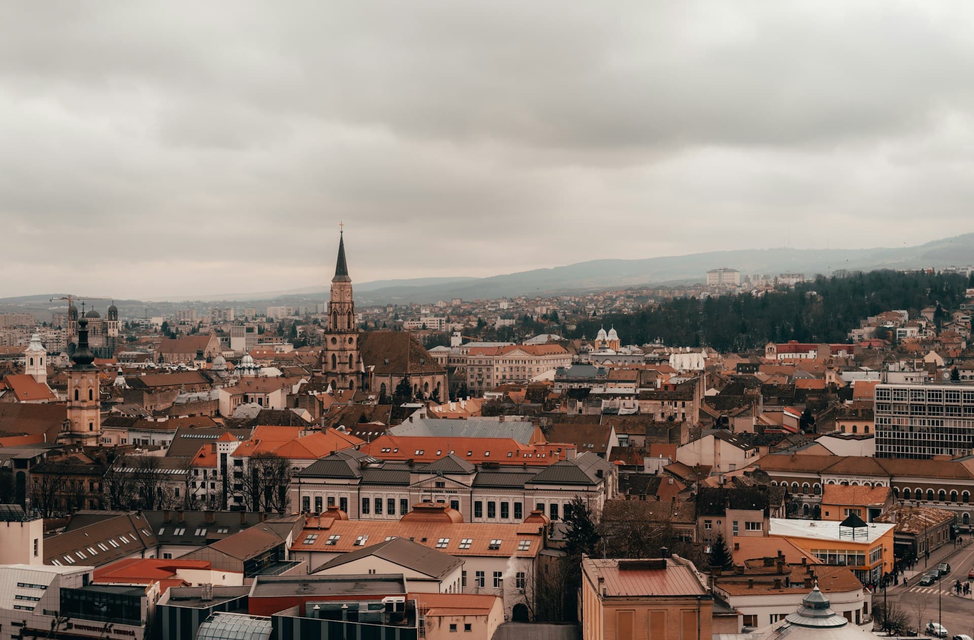 Panoramă Cluj-Napoca — case colorate sub cer senin și luminos